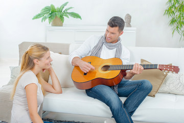 Man playing guitar to lady