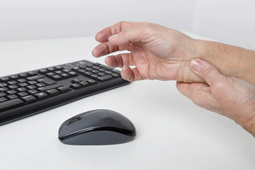 femme senior ayant mal au poignet en travaillant sur son ordinateur