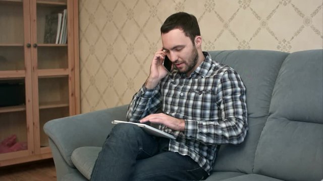 Man talking on the phone while using tablet