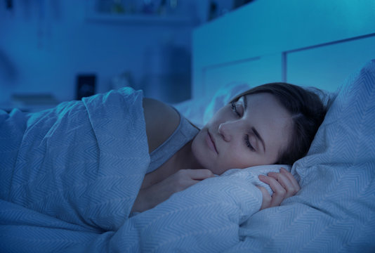 Girl peacefully sleeping in bed at night