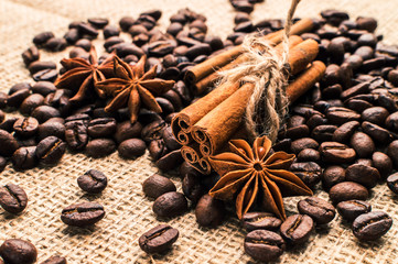 Coffee beans with cinnamon and anise on the sackcloth