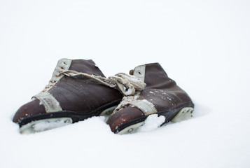 Vintage ice skates lying in the snow outdoors