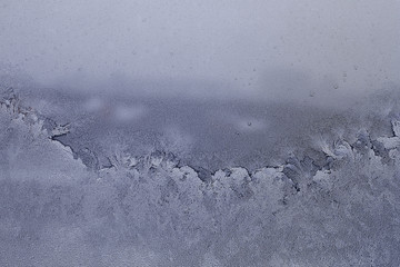 Water droplets frozen on the window glass and formed an unusual pattern.