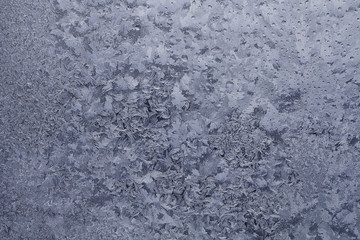 Water droplets frozen on the window glass and formed an unusual pattern.