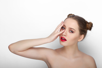 Close-up beauty portrait of young playful woman with clean fresh healthy skin funny bun hairdo on white background