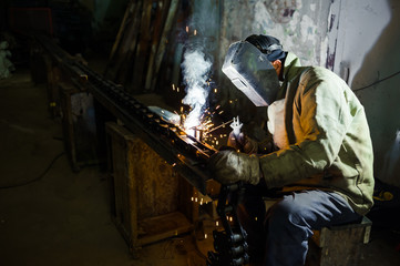 electric welding. electric welder welds metal parts factory