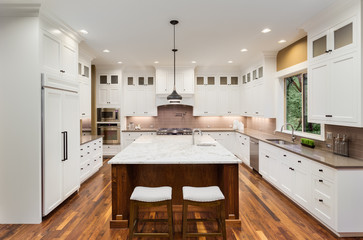 Kitchen Interior with Island, Hardwood Floors, and Pendant Lights in New Luxury Home