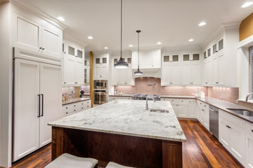 Kitchen Interior with Island, Hardwood Floors, and Pendant Lights in New Luxury Home