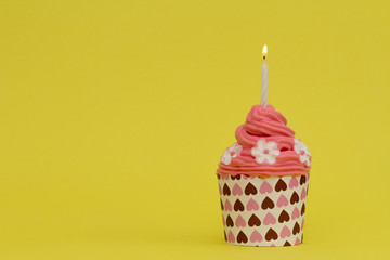 delicious cupcake with sugar flowers on yellow background