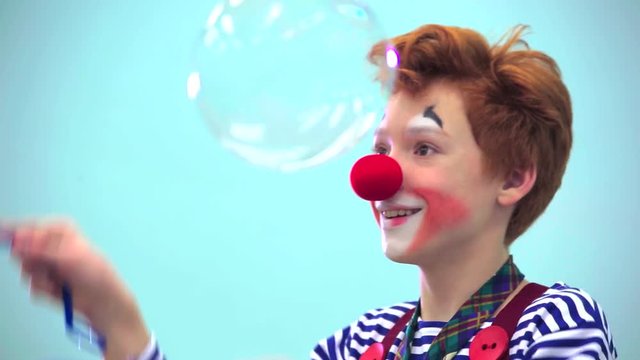 small clown  playing with soap bubbles 