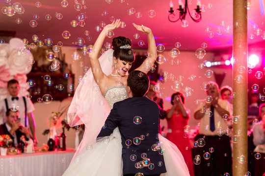 Wedding dance, happy couple dancing on wedding party with colorful special effects and bubble blower. Wedding day concept