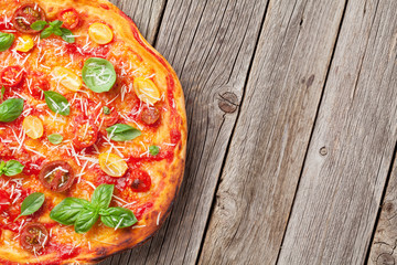 Obraz na płótnie Canvas Pizza with tomatoes, mozzarella and basil