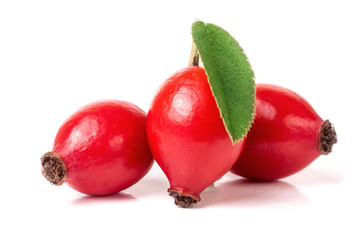 three rose hip berry with leaf isolated on white background