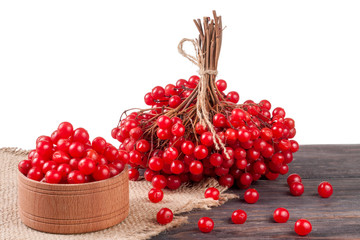 ripe red viburnum berries in a wooden bowl on the table isolated  white background
