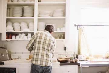 Rear view of man preparing food in the kitchen