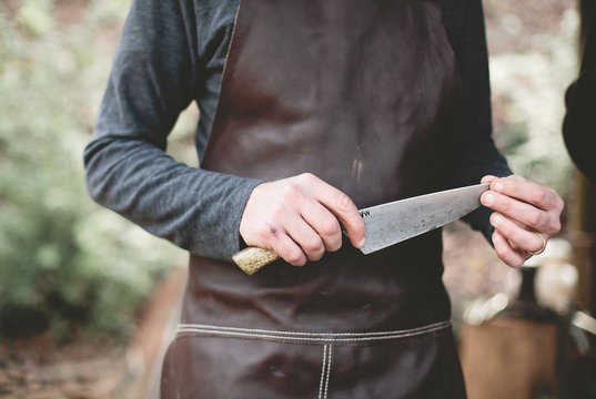 Person holding knife, feeling sharpness of blade