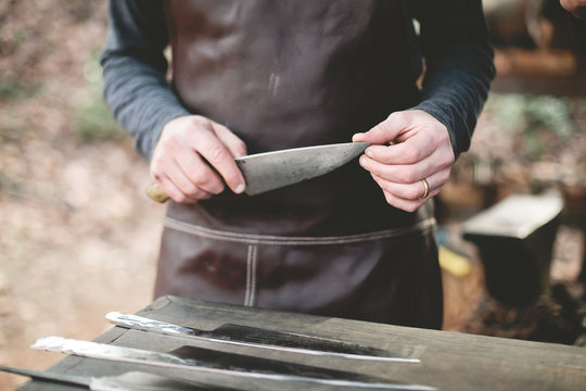 Person holding knife, feeling sharpness of blade