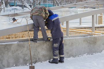 Two workers glaze the roof of the underpass