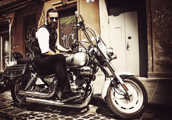 Naklejka na ściany i meble Serious Bearded Biker Man Sitting on a Motorcycle
