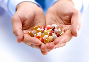 Fototapeta premium young doctor holds the patient's hand with pills