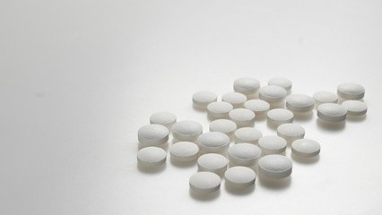 white round pills neatly stacked on a white background