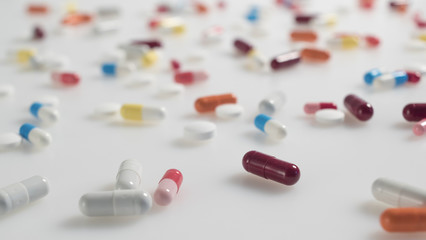 set of multicolored tablets and capsules arranged on white background close up