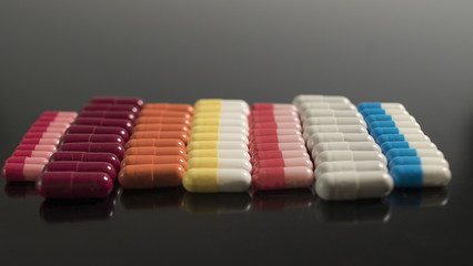 multi colored capsules neatly stacked on a black background
