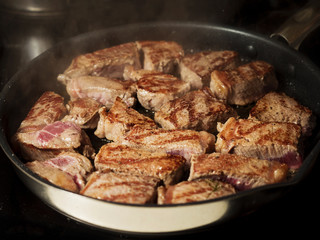 Portions of beef fillet on a frying pan.