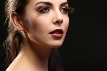 Portrait of beautiful young woman model with bright makeup on dark background