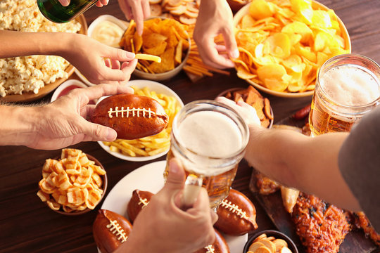 Close up view of hands taking snacks from plates during party