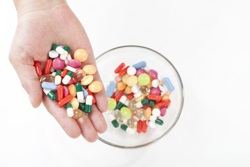 Top view of female hands holding different pills