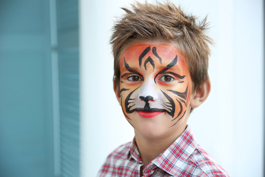 Cute little boy with aqua makeup of tiger muzzle