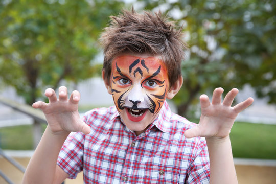 Cute little boy with aqua makeup of tiger muzzle