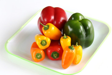 assorted bell peppers isolated on  a white plate. pepper mix
