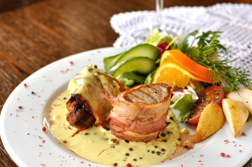 Grilowana polędwica w boczku z sosem z zielonego pieprzu.