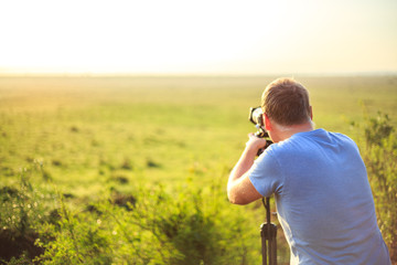 Professional photographer taking photo on savannah