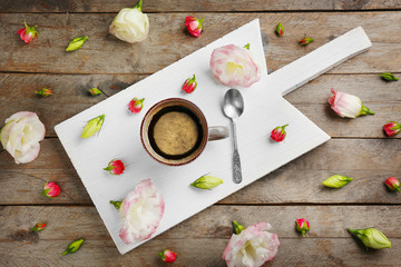 Beautiful composition with cup of coffee and flowers on wooden background