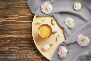 Obraz na płótnie Canvas Beautiful composition with cup of coffee and flowers on wooden background