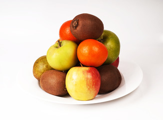 Still life lot of different fruits on the plate kiwi Mandarin pe