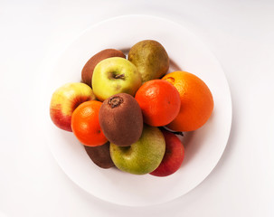 Still life lot of different fruits on the plate kiwi Mandarin pe