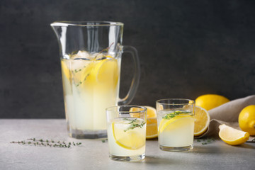 Glasses and jug of fresh lemonade on table