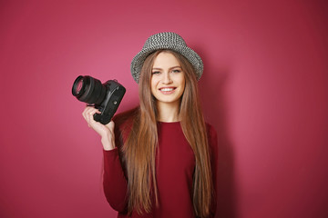 Beautiful young photographer on color background