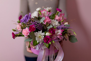 A womans hand is holding a bouquet of flowers