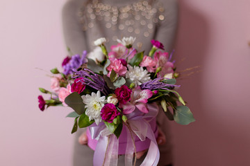 A womans hand is holding a bouquet of flowers