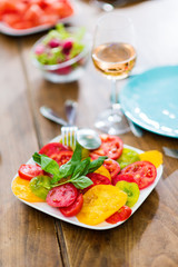 Close-up on a plate of tomato salad on a wooden table