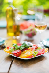 Close-up on a plate of tomato salad on a wooden table