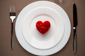 Red heart - a symbol of love on the white plate.