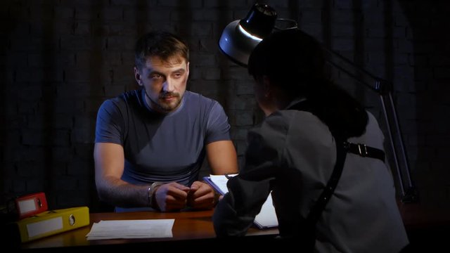 Interrogation of criminal man in handcuffs