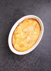 Casserole with fish in a white dish on a black background