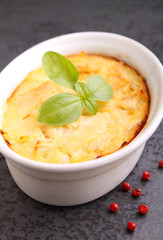 Casserole with fish in a white dish on a black background